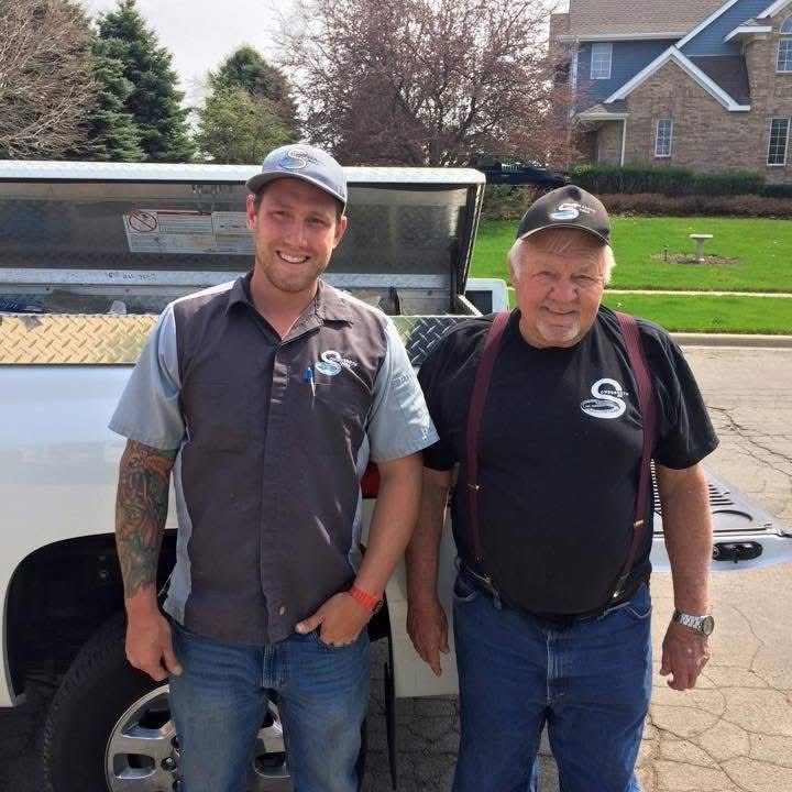 Zack Sondgeroth standing beside his grandfather, founder of Sondgeroth Pools, continuing the family legacy of pool building.