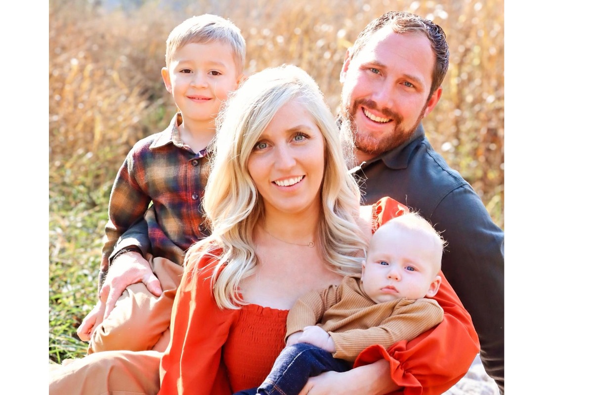 Family portrait of Sondgeroth Pools owners smiling outdoors with their two young children.