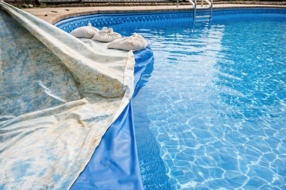 Old pool liner being removed and replaced with a new blue vinyl liner during pool liner replacement